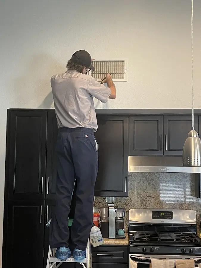 Technician inspecting an air vent during HVAC service in Gulfport